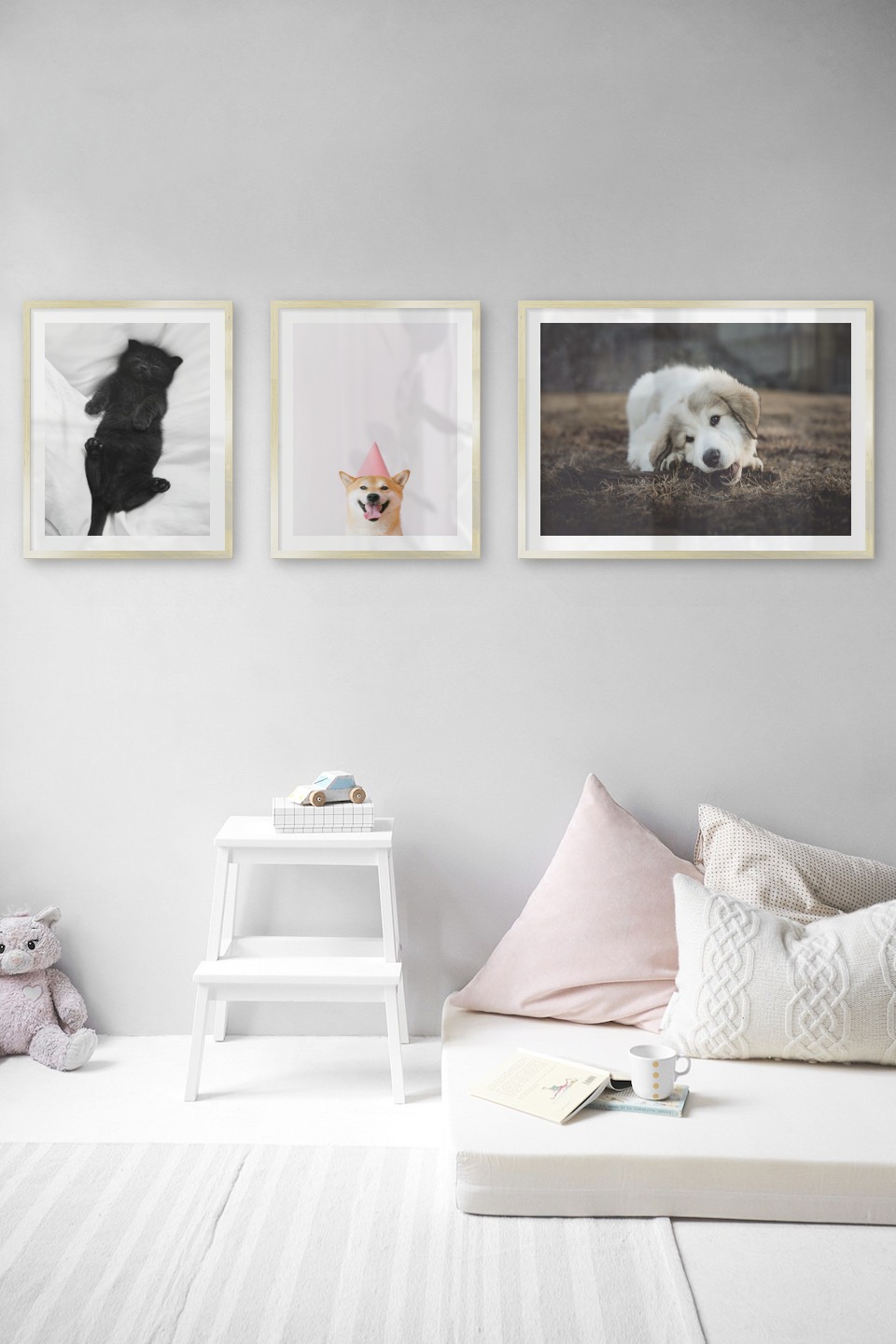 Tavelvägg med ramar i guld i storlekar 40x50 och 50x70 med posters med "Katt i säng", "Hund med rosa hatt" och "Hund som tuggar"