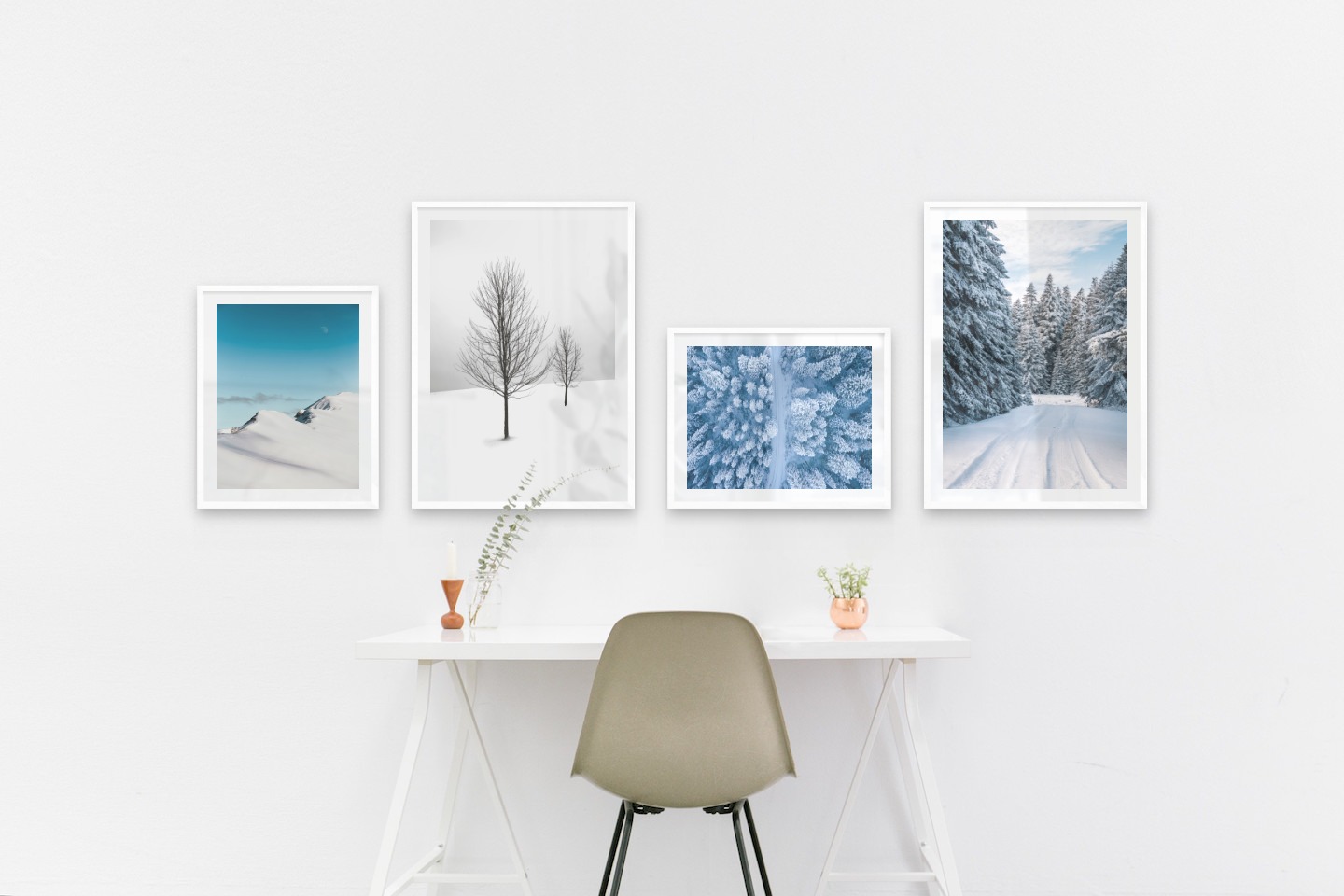 Tavelvägg med ramar i vitt i storlekar 40x50 och 50x70 med posters med "Snöiga bergstoppar", "Träd i snön", "Vinterväg ovanifrån" och "Snöig väg"