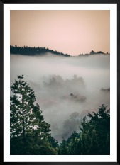 Tavelvägg med ram i svart i storlek 50x70 med poster med "Trätoppar och orange himmel"